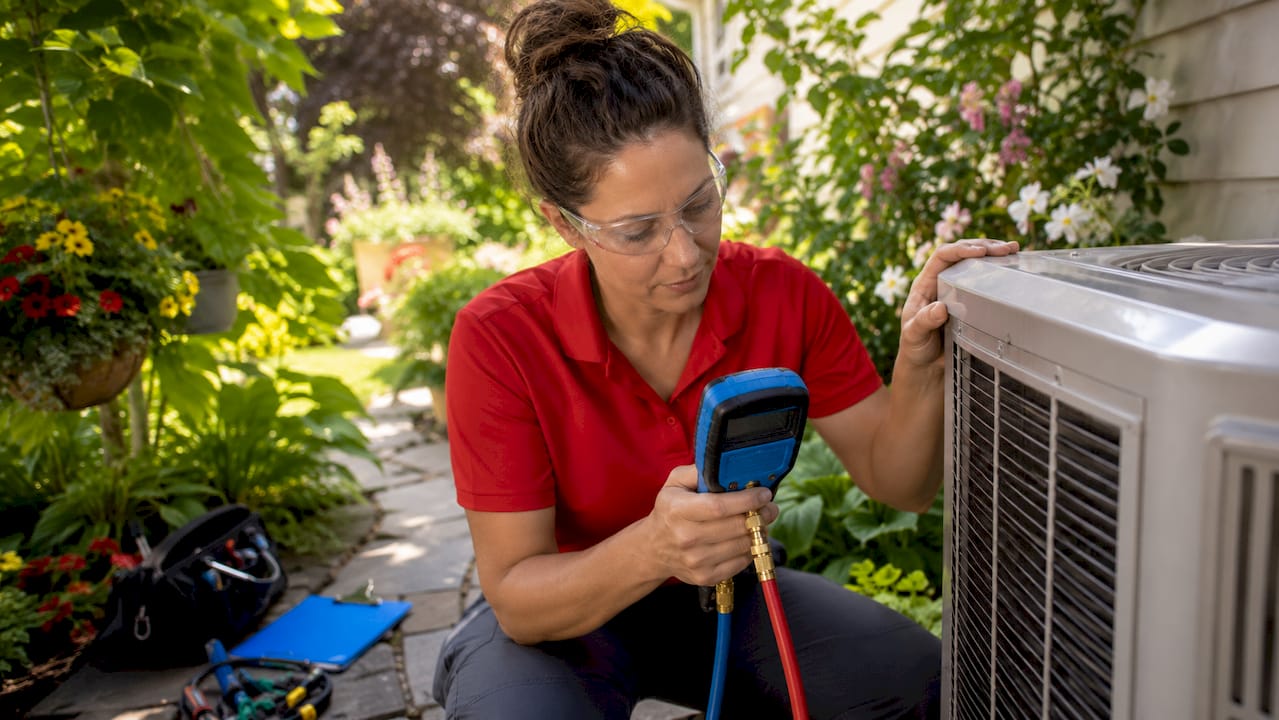 HVAC technician performing outdoor seasonal check