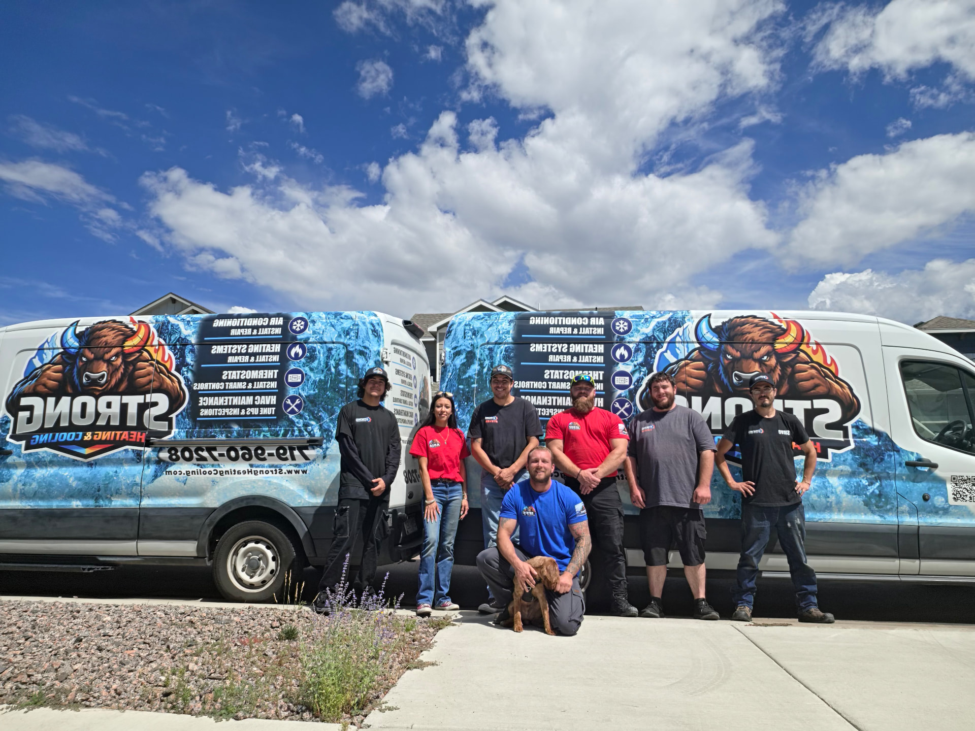 The Strong Heating & Cooling team standing in front of their wrapped service vans in Colorado Springs